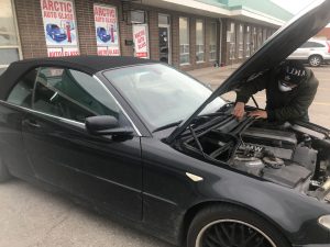 Artic Auto Glass expert working on the BMW front windshield customer car
